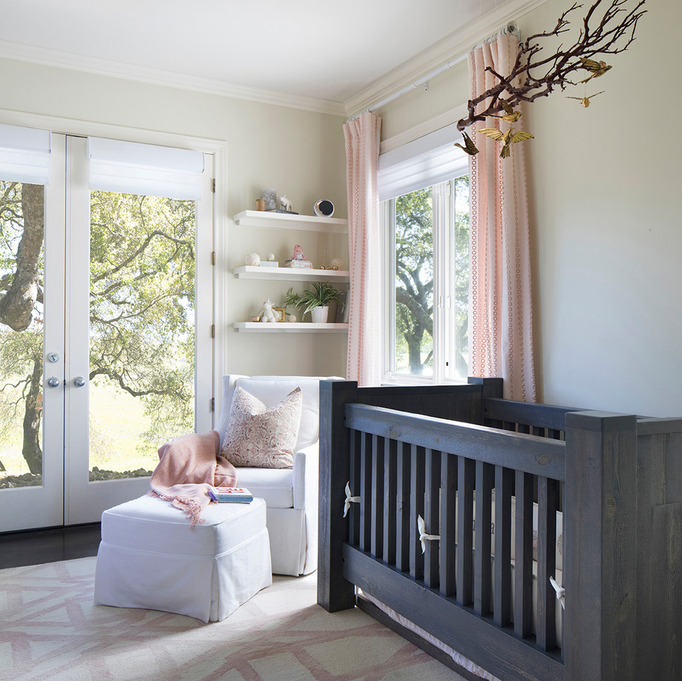 На фото: комната для малыша в стиле неоклассика (современная классика) с бежевыми стенами, темным паркетным полом и серым полом для девочки