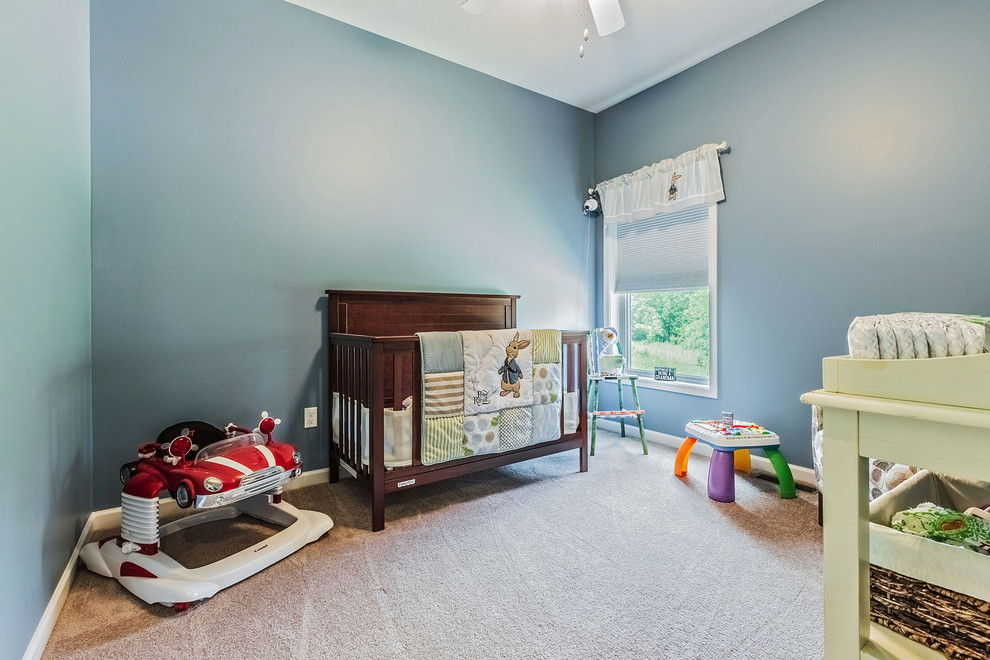 Diseño de habitación de bebé niño clásica grande con paredes azules, moqueta y suelo beige