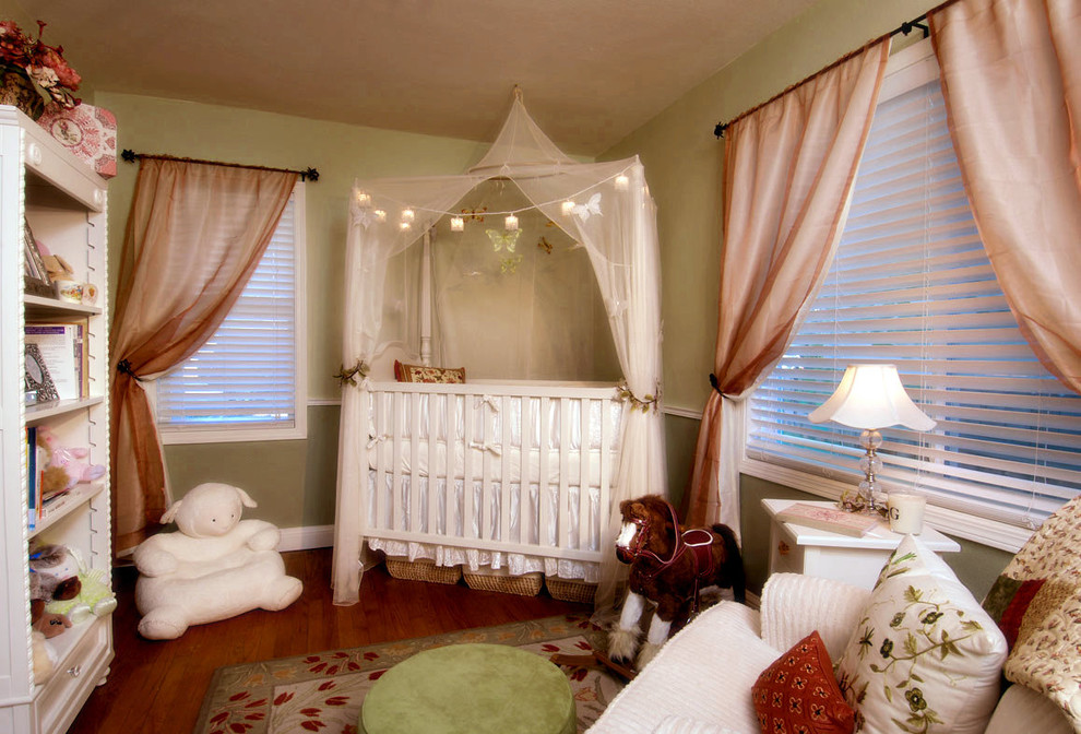 Exemple d'une chambre de bébé éclectique avec un mur vert.