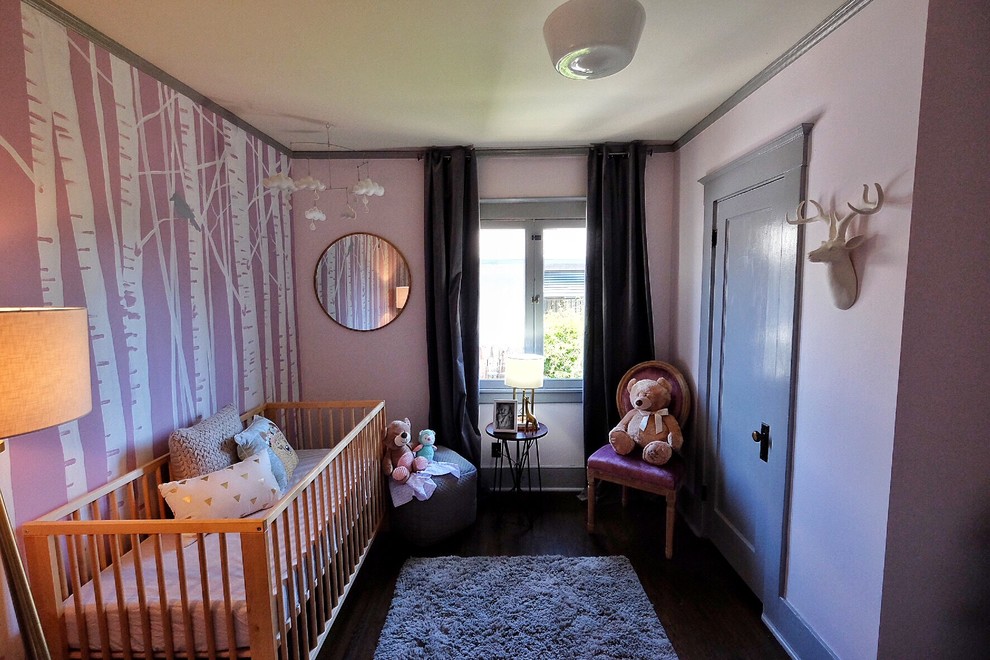 Modern inredning av ett litet babyrum, med rosa väggar och mörkt trägolv