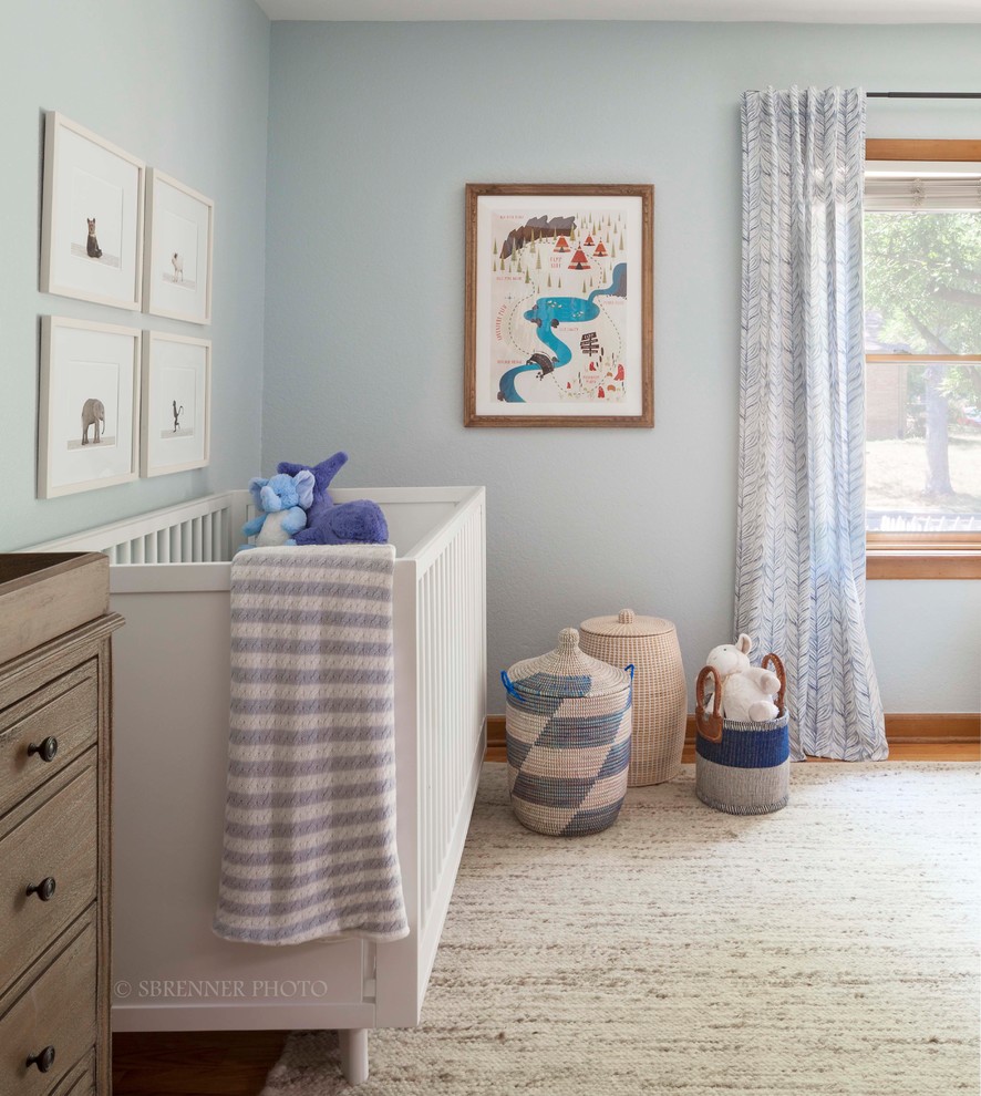 Imagen de habitación de bebé niño tradicional renovada con paredes azules y suelo de madera en tonos medios