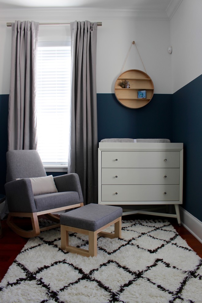 Idee per una cameretta per neonato minimalista di medie dimensioni con pareti blu e pavimento in legno massello medio