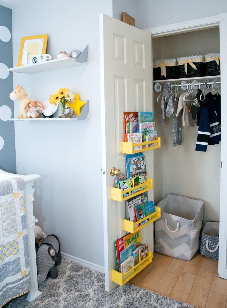 Example of a transitional gender-neutral medium tone wood floor nursery design in Toronto with gray walls