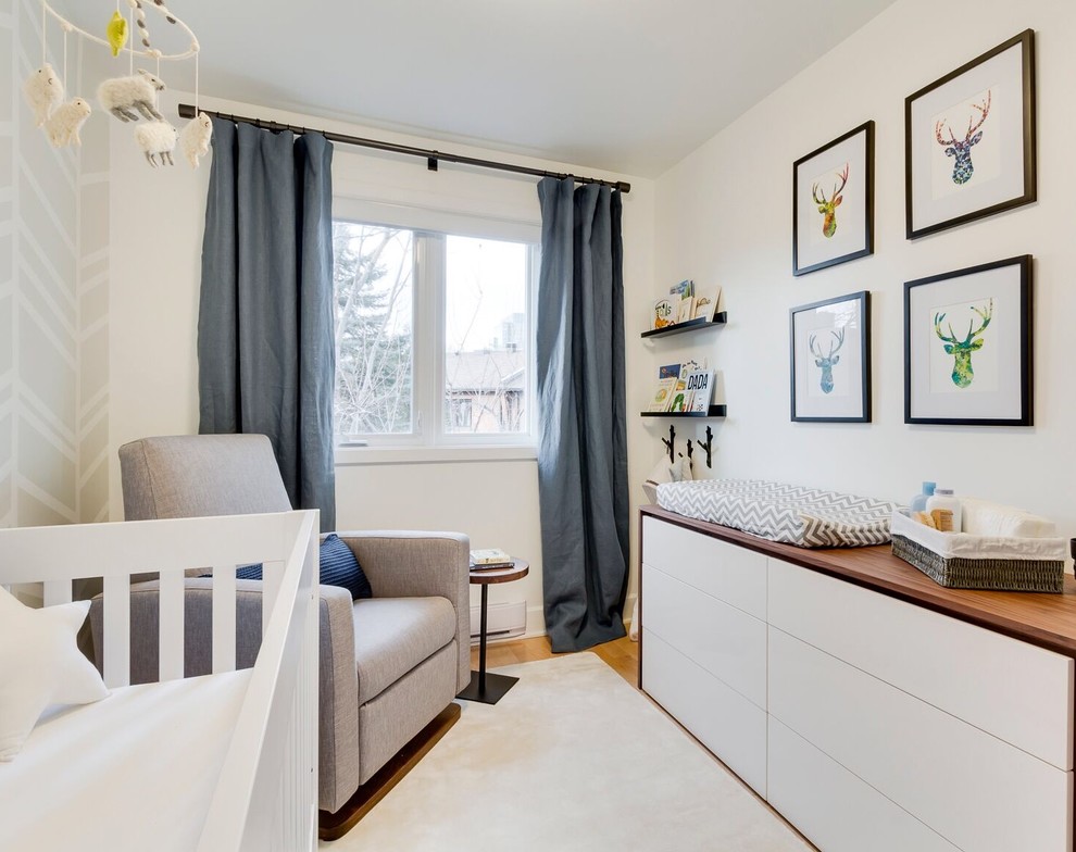 Kleines Modernes Babyzimmer mit weißer Wandfarbe und hellem Holzboden in Montreal