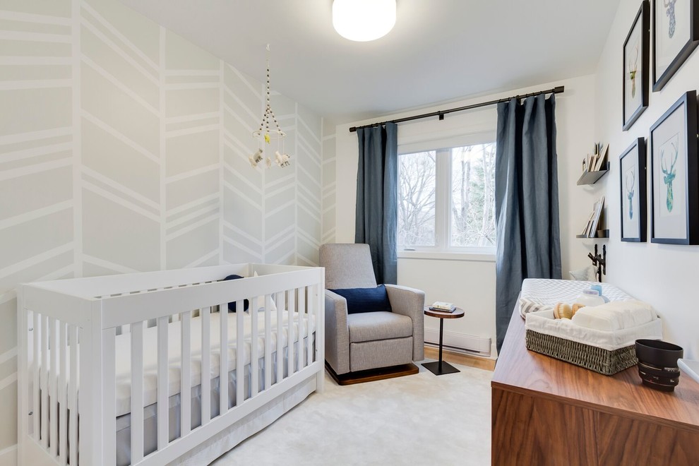 Photo of a small contemporary nursery for boys in Montreal with white walls and light hardwood flooring.