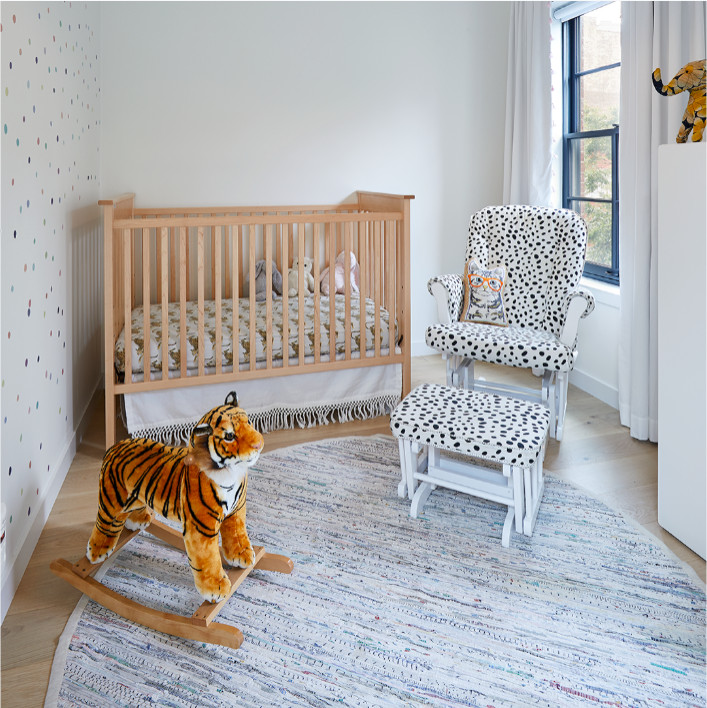 Ejemplo de habitación de bebé neutra clásica renovada de tamaño medio con paredes blancas, suelo de madera clara y suelo beige