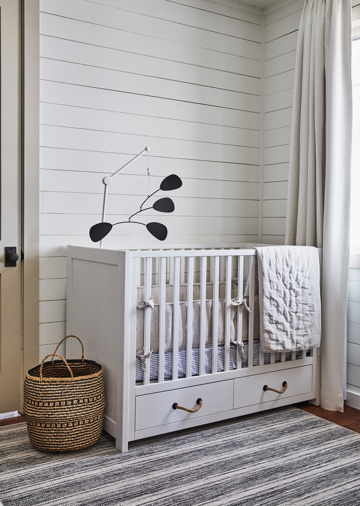 This is an example of a medium sized beach style gender neutral nursery in Dallas with white walls, medium hardwood flooring and brown floors.