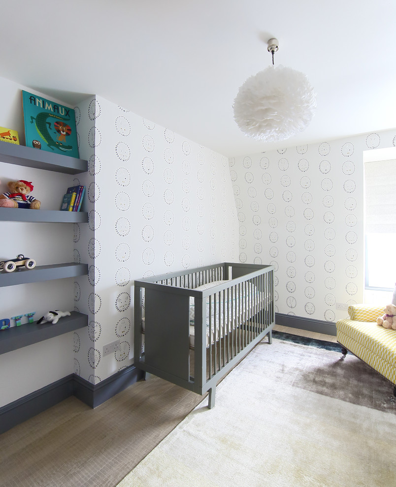 Neutrales, Mittelgroßes Skandinavisches Babyzimmer mit braunem Holzboden und weißer Wandfarbe in London