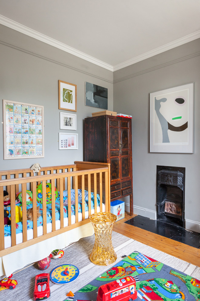 Design ideas for a traditional nursery in London with grey walls and medium hardwood flooring.