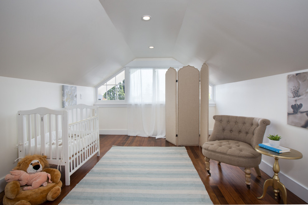 Bild på ett mellanstort amerikanskt babyrum, med vita väggar, mörkt trägolv och brunt golv