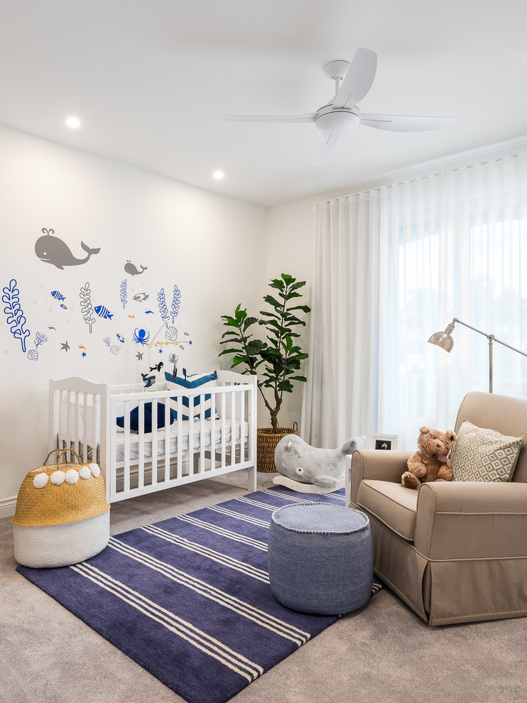Immagine di una cameretta per neonati neutra stile marinaro con pareti bianche e moquette