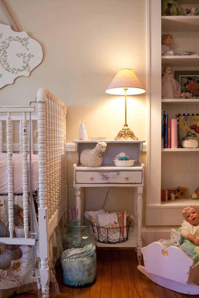 Inspiration for a shabby-chic style nursery for girls in Nashville with beige walls and light hardwood flooring.