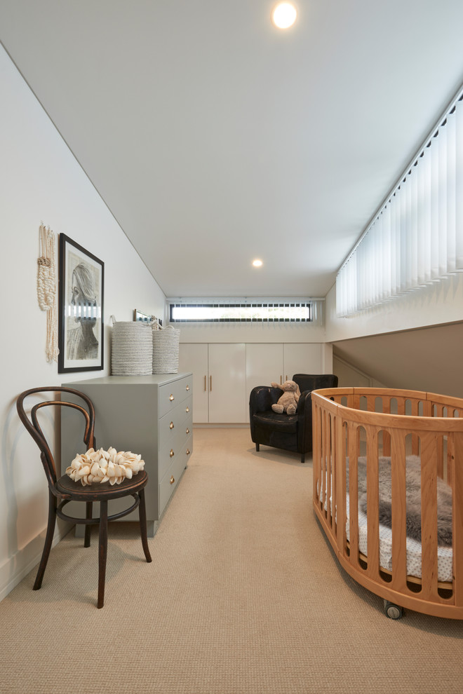 Idées déco pour une chambre de bébé neutre contemporaine avec un mur beige, sol en béton ciré et un sol beige.
