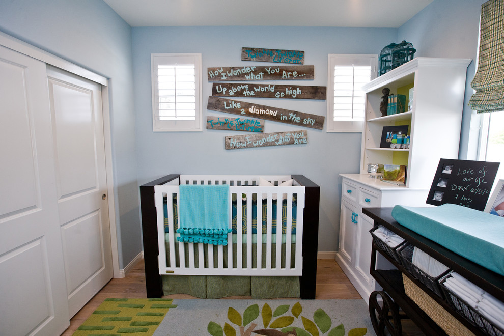 Aménagement d'une petite chambre de bébé garçon classique avec un mur bleu et parquet clair.