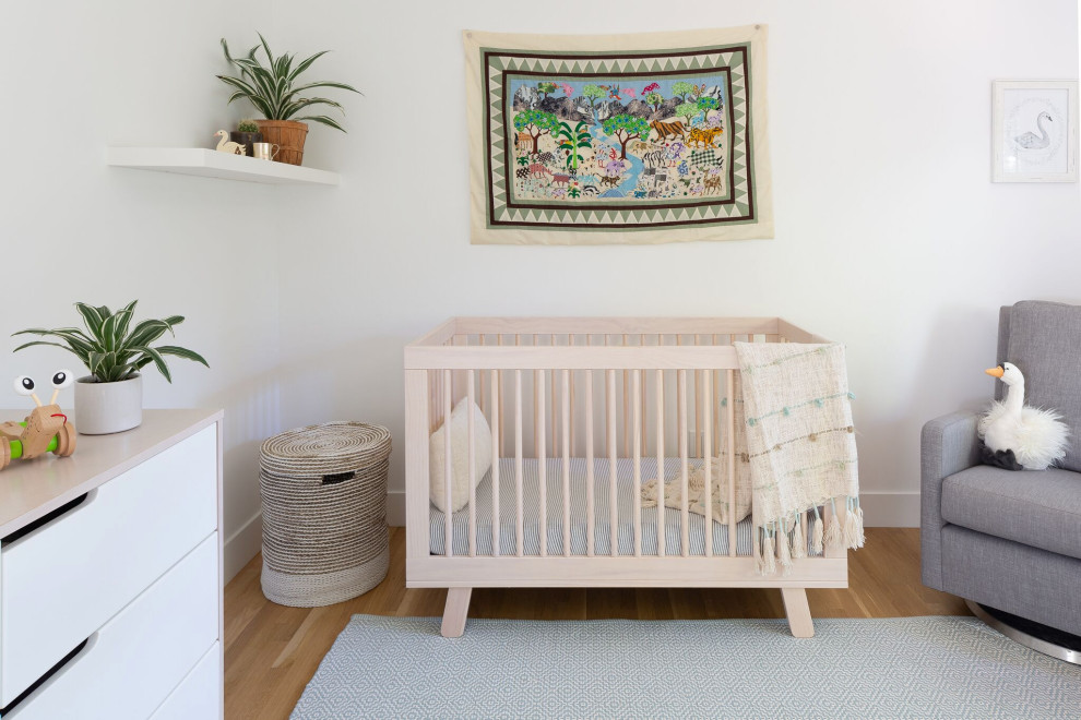 Réalisation d'une chambre de bébé fille tradition de taille moyenne avec un mur blanc, parquet clair et un sol marron.