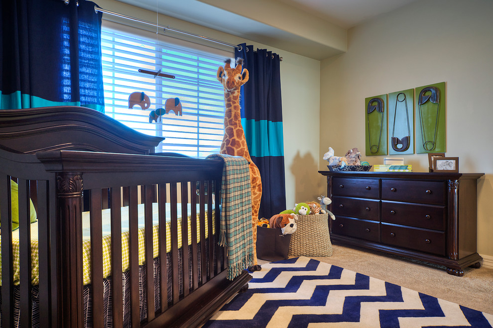 Large trendy boy carpeted nursery photo in Orange County with beige walls