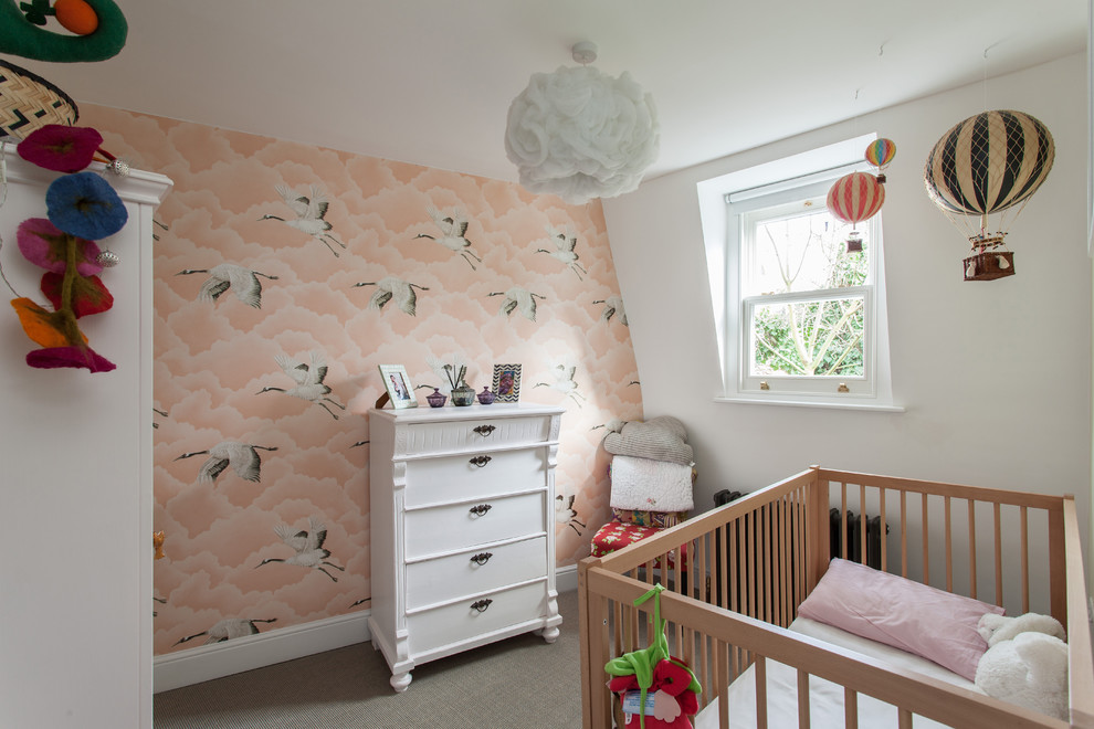 Traditional nursery in London with pink walls, carpet, grey floors and feature lighting.