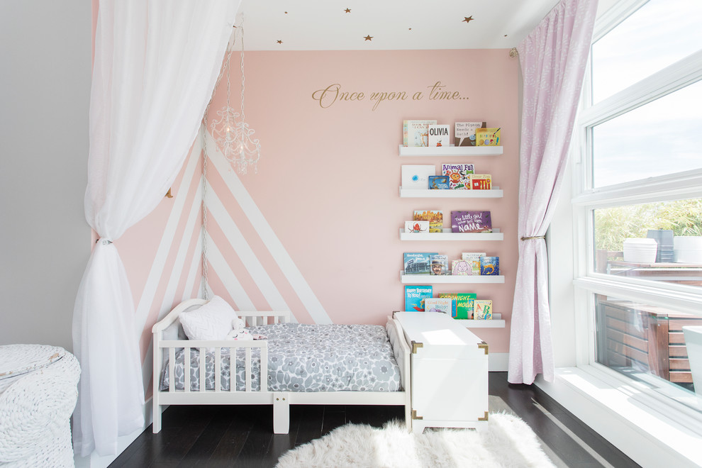 Immagine di una cameretta per neonata tradizionale di medie dimensioni con pareti grigie, parquet scuro e pavimento marrone