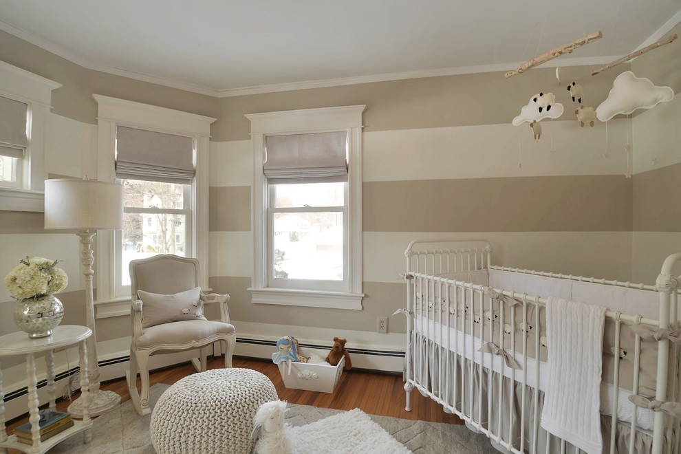 Foto de habitación de bebé neutra tradicional pequeña con suelo de madera en tonos medios y paredes blancas