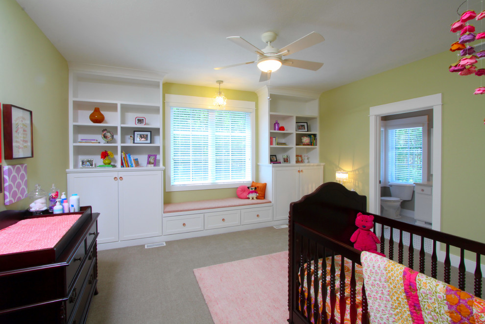 Diseño de habitación de bebé de estilo americano grande con paredes verdes y moqueta