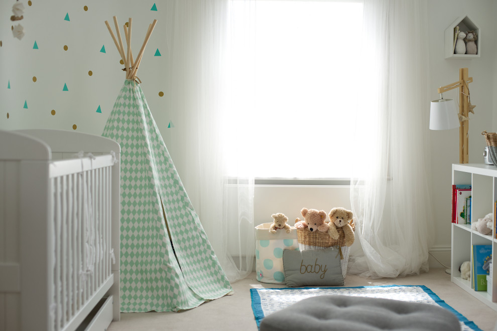 Small eclectic gender neutral nursery in London with white walls, carpet and beige floors.