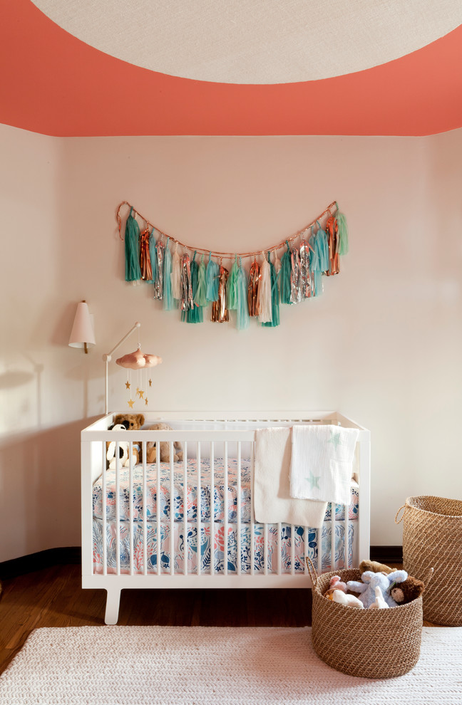 Idées déco pour une chambre de bébé neutre classique avec un mur beige et un sol en bois brun.