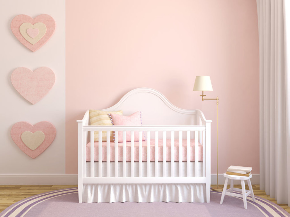 Cette photo montre une chambre de bébé fille chic de taille moyenne avec un mur rose, parquet clair et un sol marron.