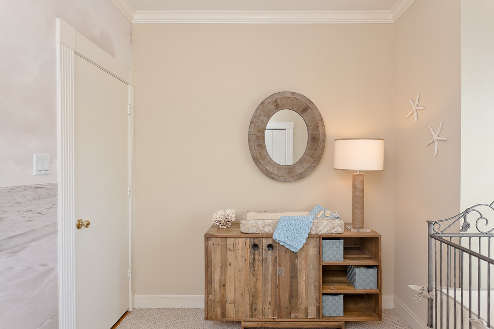 Réalisation d'une petite chambre de bébé neutre marine avec un mur beige et moquette.