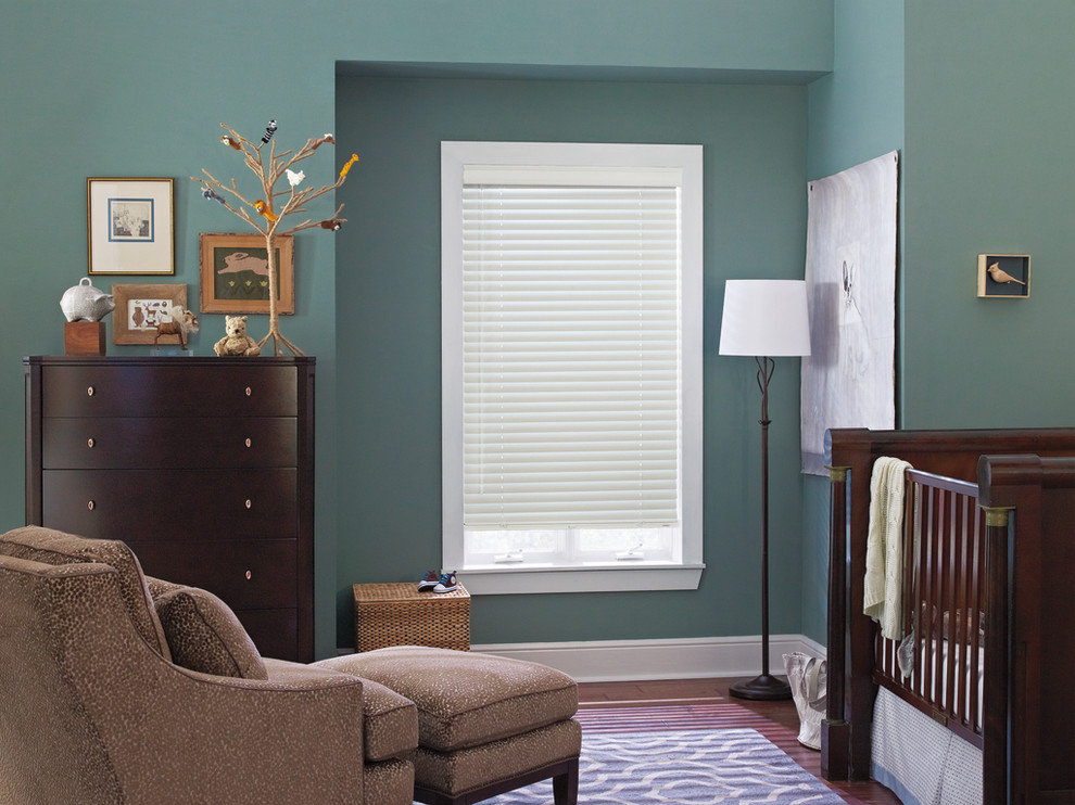 This is an example of a medium sized traditional gender neutral nursery in Other with blue walls and dark hardwood flooring.