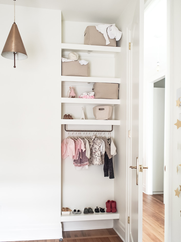 Idée de décoration pour une petite chambre de bébé neutre tradition avec un mur blanc, parquet clair et un sol marron.
