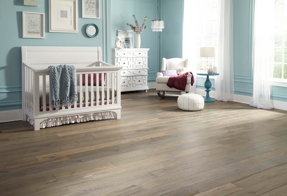 Cette photo montre une grande chambre de bébé neutre romantique avec un mur bleu, un sol en bois brun et un sol gris.