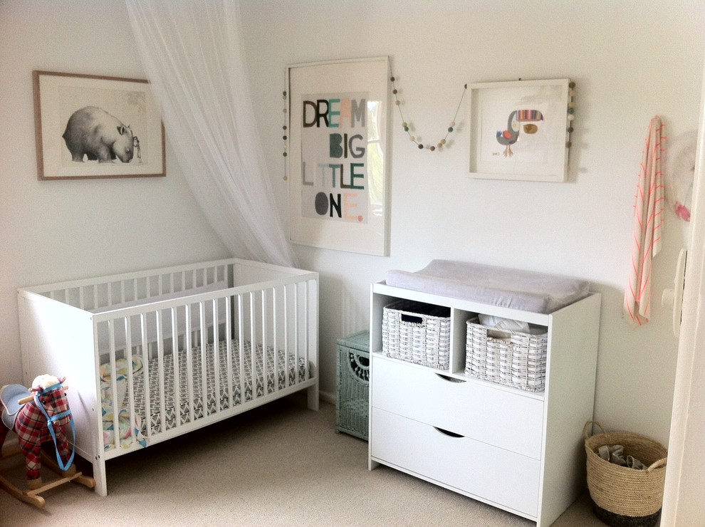 Photo of a small scandinavian gender neutral nursery in Sydney with white walls, carpet and beige floors.