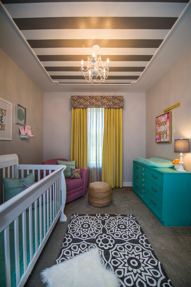 This is an example of a small bohemian nursery for girls in Omaha with grey walls and carpet.