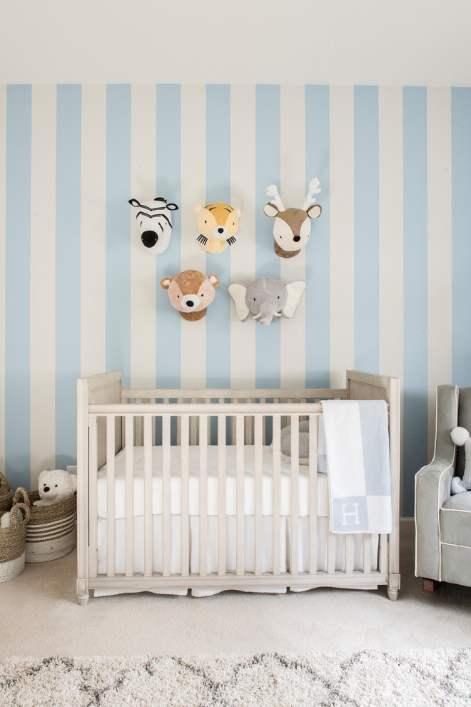 Traditional nursery for boys in Orange County with carpet, blue walls and beige floors.