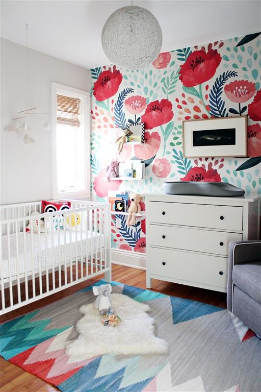 Imagen de habitación de bebé niña moderna de tamaño medio con paredes grises y suelo de madera clara