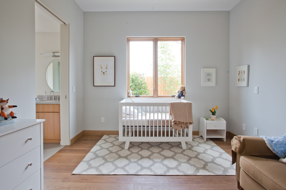 Réalisation d'une chambre de bébé fille design avec un mur gris.