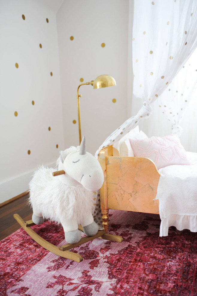 Idée de décoration pour une chambre de bébé tradition de taille moyenne avec un mur blanc, parquet foncé et un sol marron.