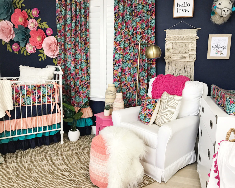 Photo of a small bohemian nursery for girls in Austin with blue walls, laminate floors and beige floors.
