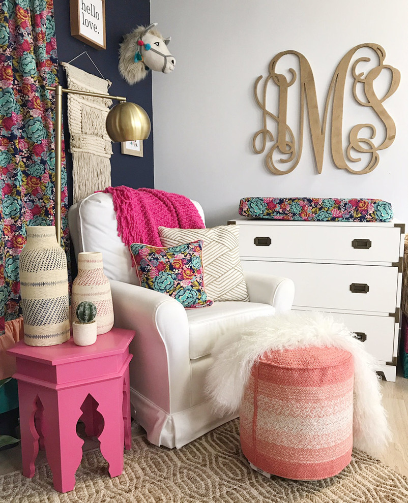Design ideas for a small eclectic nursery for girls in Austin with blue walls, laminate floors and beige floors.