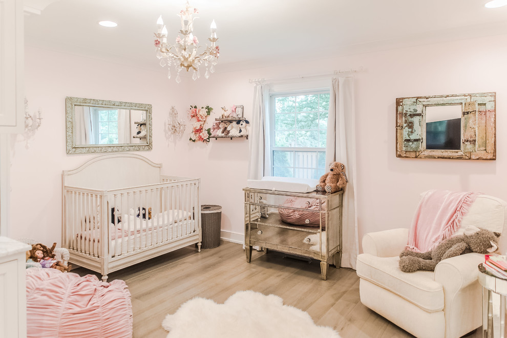 Пример оригинального дизайна: большая комната для малыша: освещение в классическом стиле с паркетным полом среднего тона и розовыми стенами для девочки