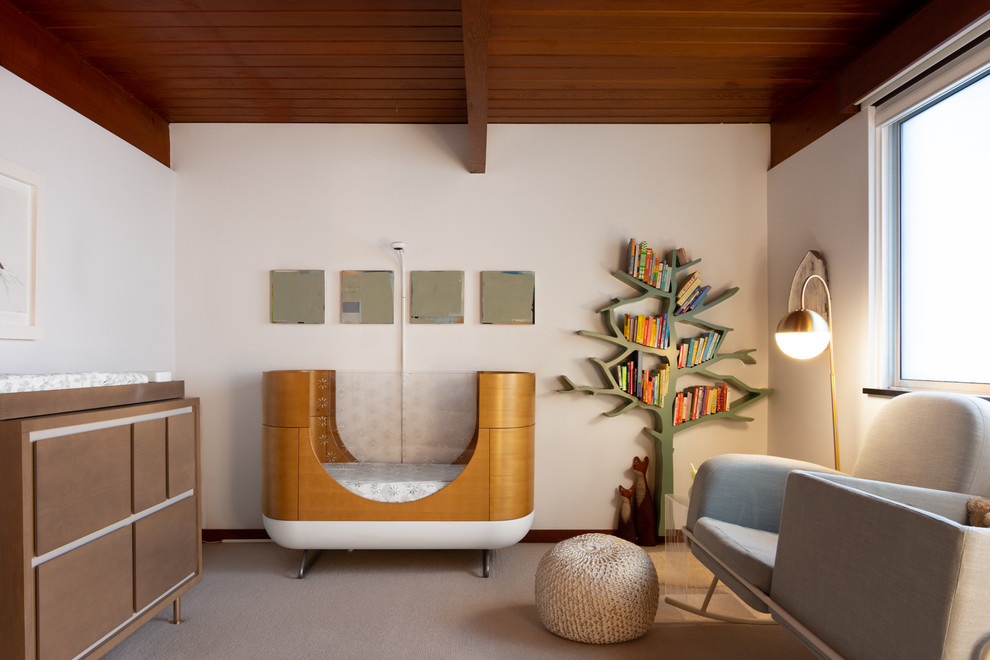 Diseño de habitación de bebé neutra retro de tamaño medio con paredes blancas, moqueta y suelo beige