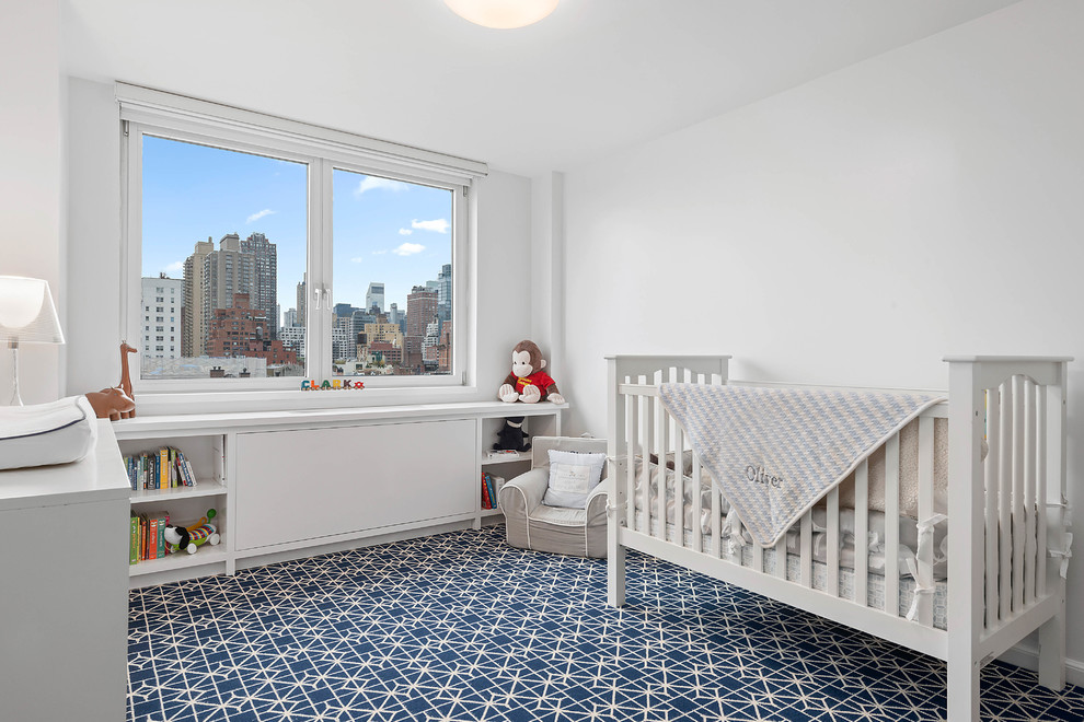 Example of a mid-sized transitional boy carpeted and blue floor nursery design in New York with white walls