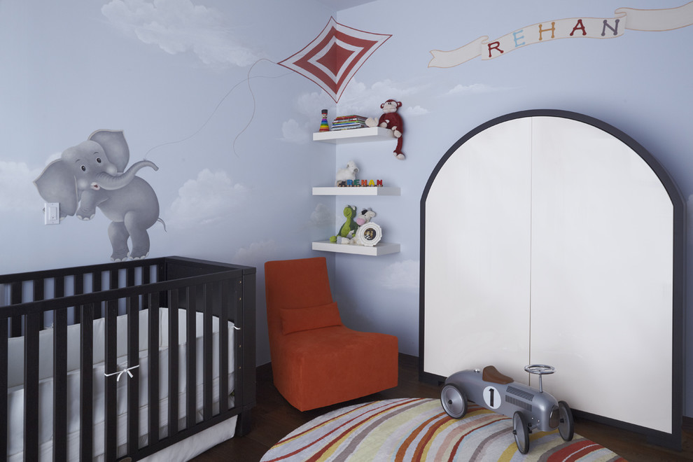 Ejemplo de habitación de bebé neutra actual con paredes azules y suelo de madera oscura