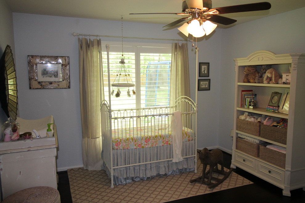 Esempio di una grande cameretta per neonati chic con pareti blu e parquet scuro