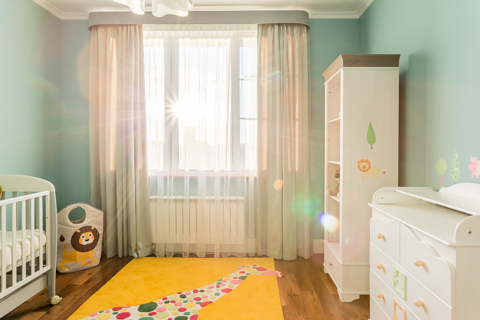 Источник вдохновения для домашнего уюта: нейтральная комната для малыша среднего размера с синими стенами и паркетным полом среднего тона