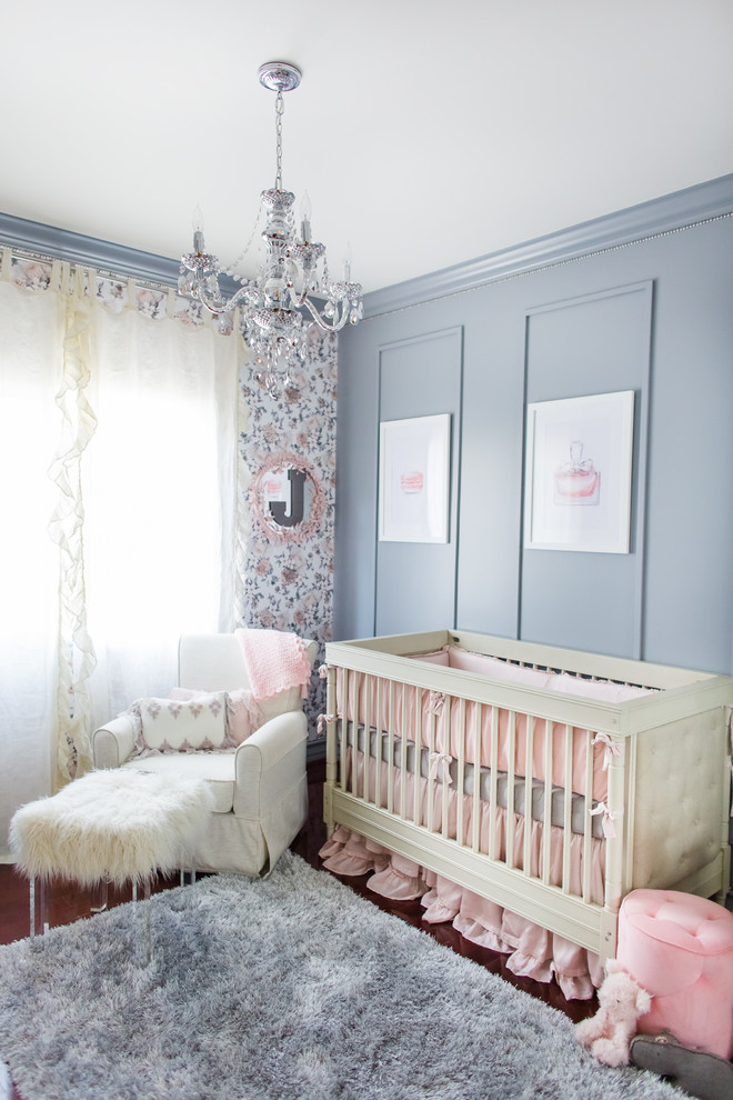 Imagen de habitación de bebé niña moderna grande con paredes grises y suelo de madera oscura