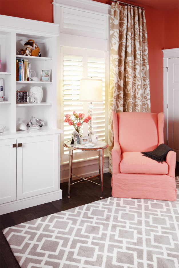 Modelo de habitación de bebé niña clásica de tamaño medio con parades naranjas y suelo de madera en tonos medios