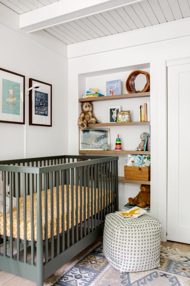 На фото: комната для малыша в морском стиле с белыми стенами, паркетным полом среднего тона, коричневым полом, балками на потолке и потолком из вагонки