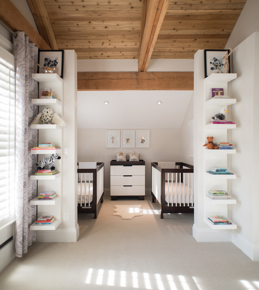 Ejemplo de habitación de bebé neutra actual de tamaño medio con paredes blancas, moqueta y suelo beige