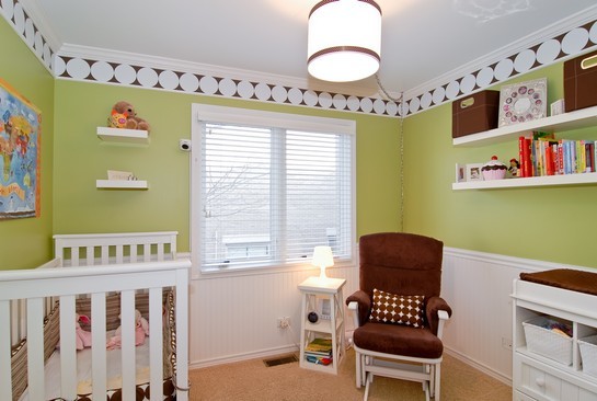 Esempio di una piccola cameretta per neonata chic con pareti verdi e moquette